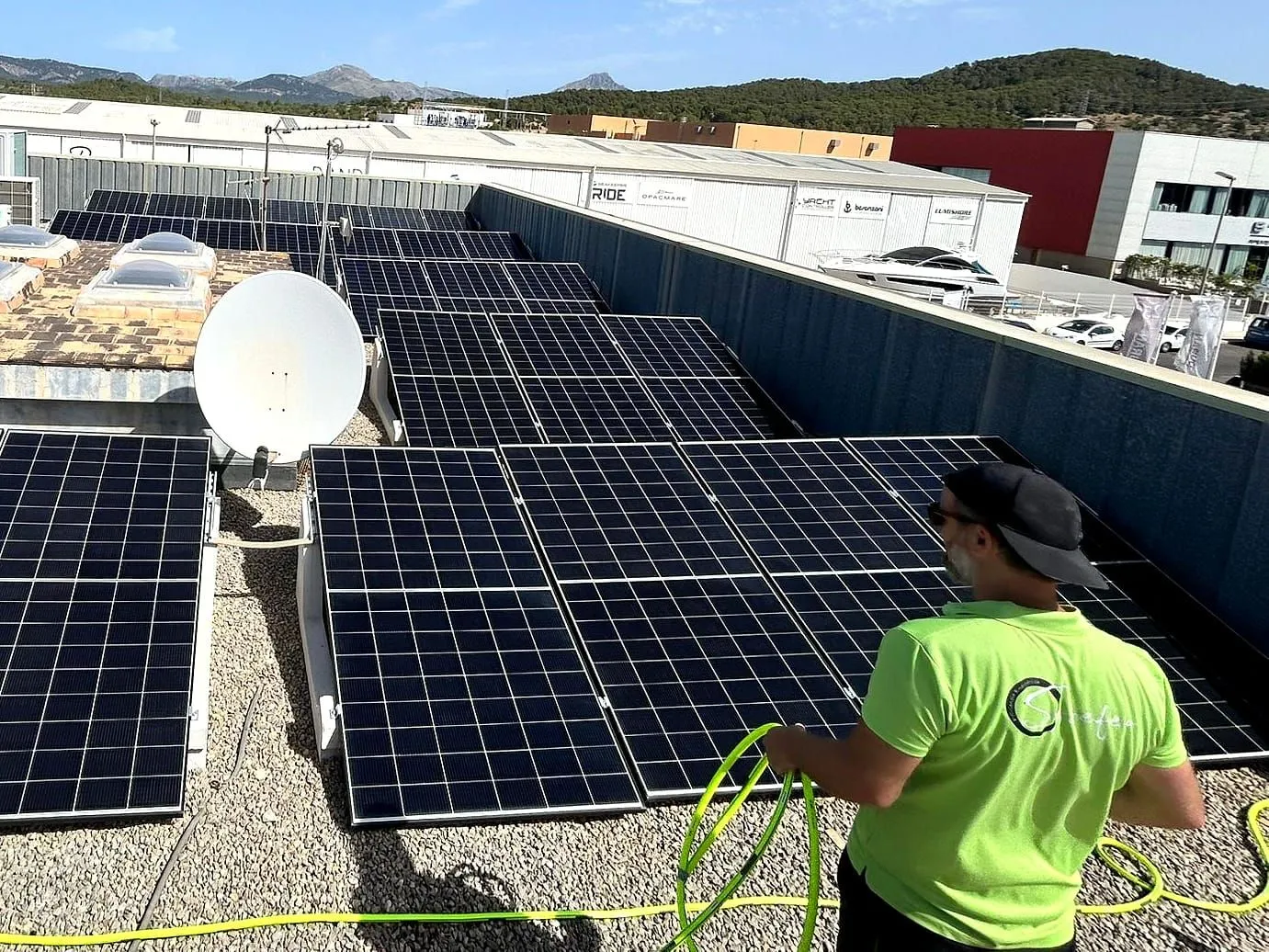 Sysefen-Techniker prüft eine Photovoltaikanlage auf dem Flachdach einer Gewerbehalle auf Mallorca